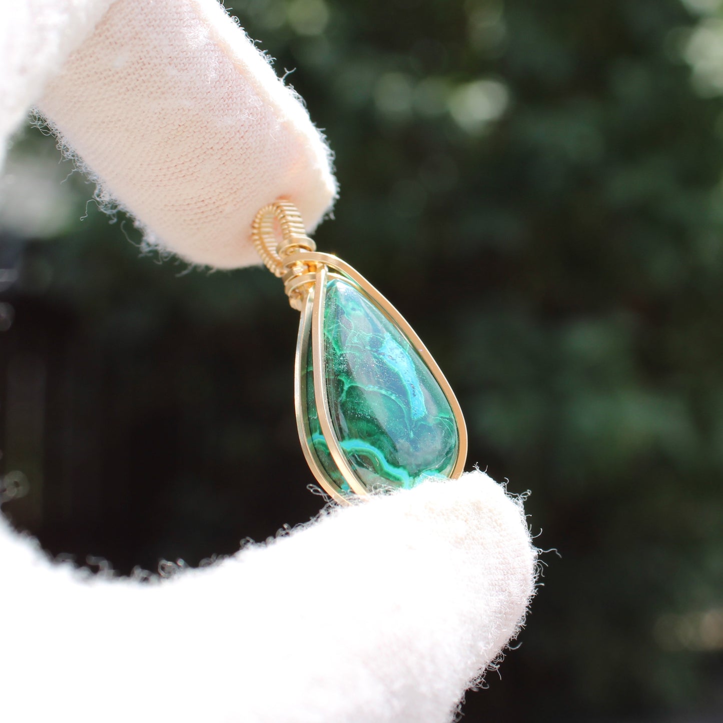 14k Gold Filled Chrysocolla Malachite teardrop pendant held by white gloves