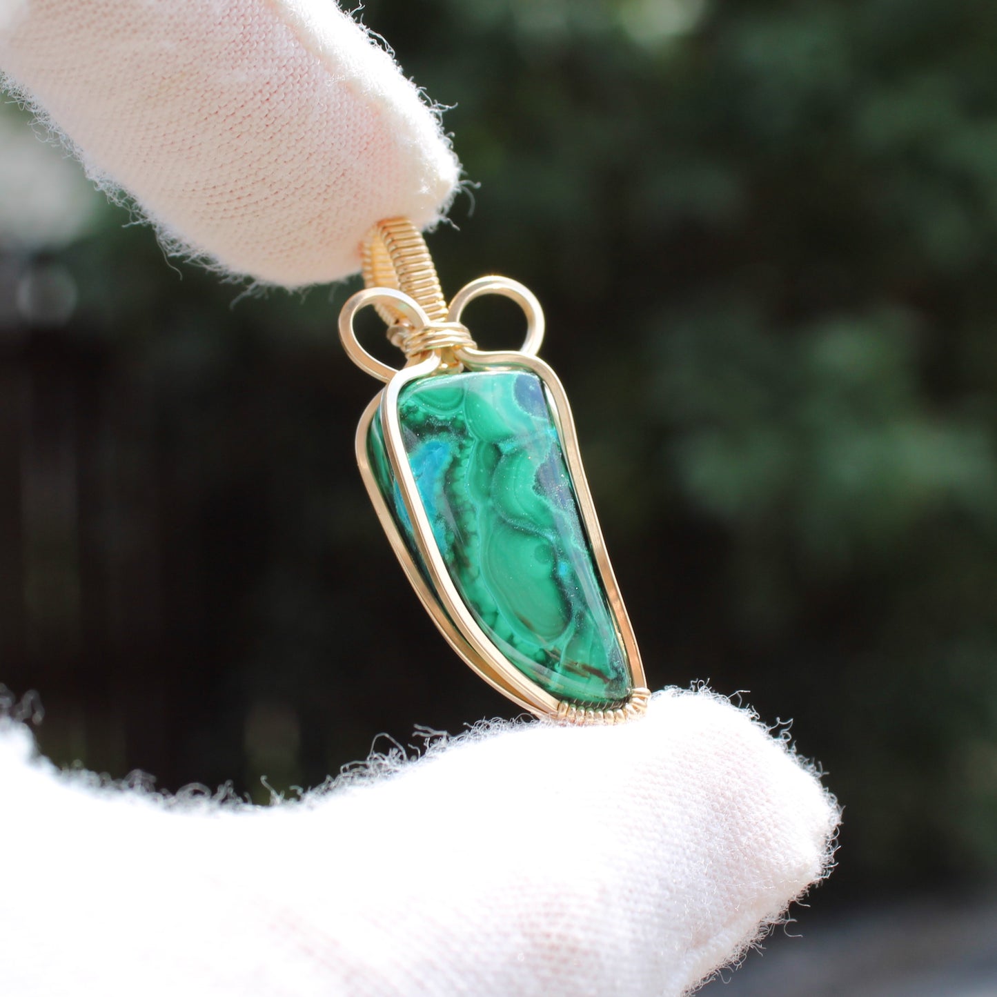 14k Gold Filled Chrysocolla Malachite pendant held by gloved hand with detailed gold wire wrapping