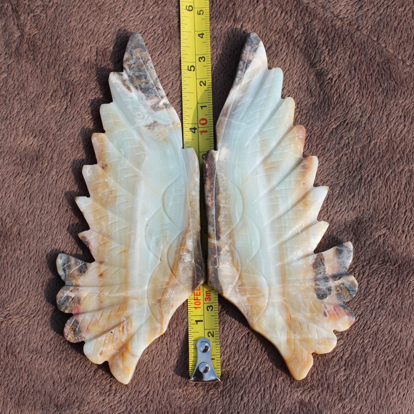Different Branches LLC Amazonite Owl Wings crystal in natural shades with measuring tape on brown fabric