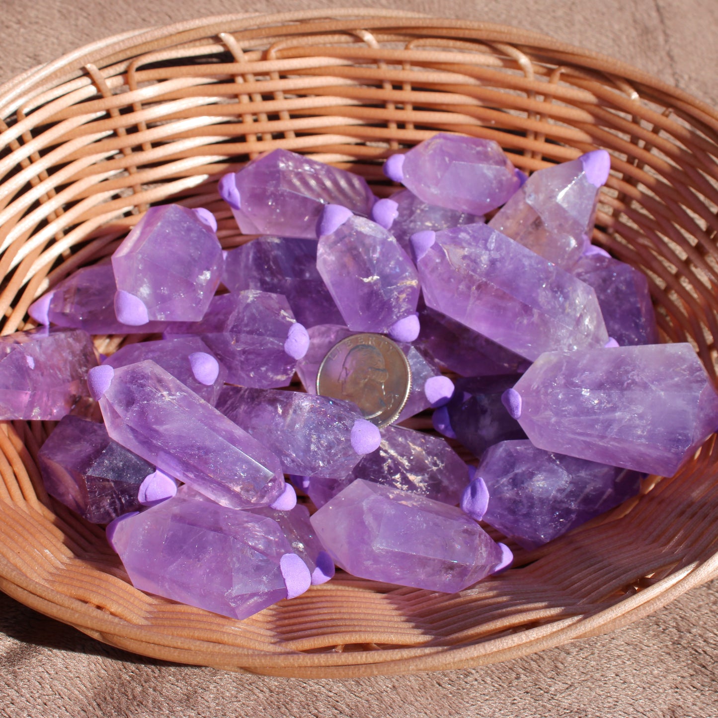 Amethyst double points in a woven basket showcasing their vibrant purple color and unique shapes