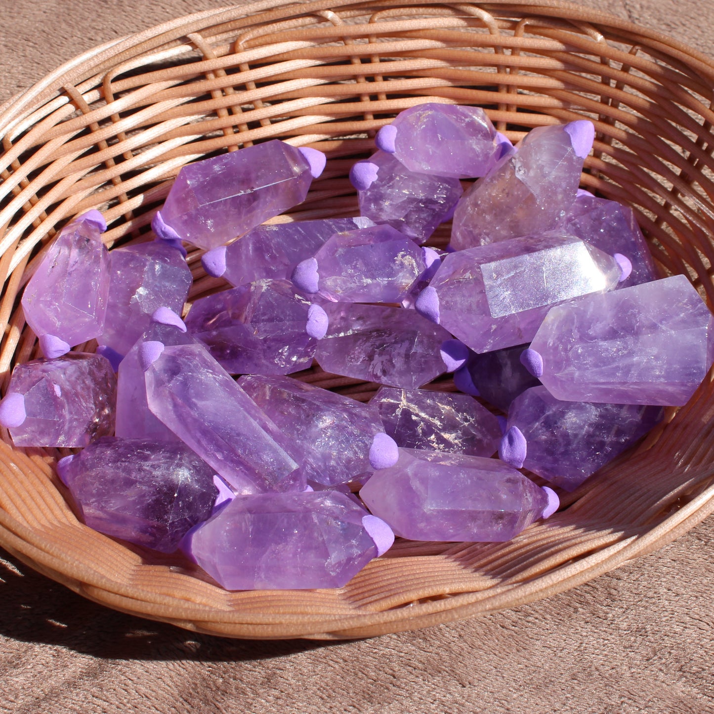 Amethyst double points in a wicker basket showcasing their beautiful purple color and unique shapes