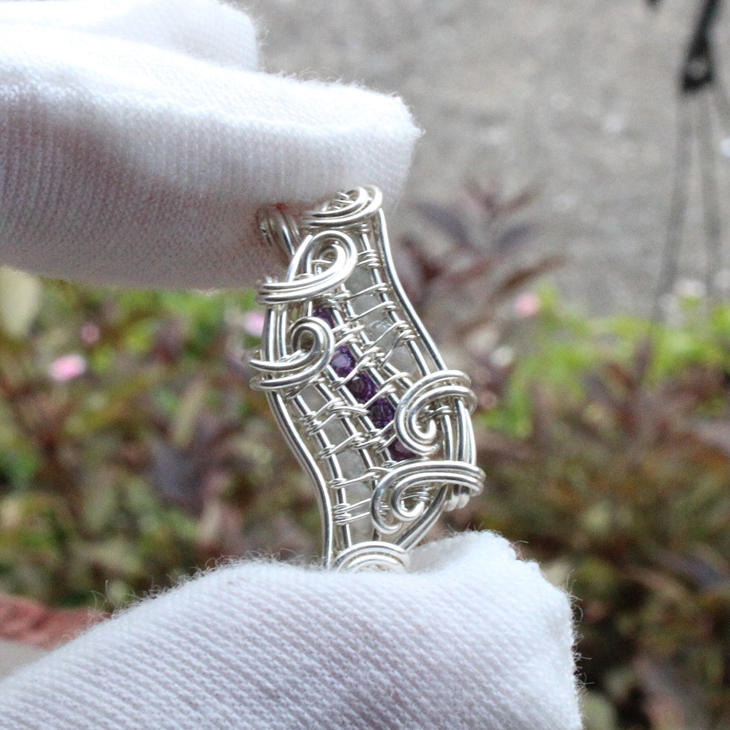 Amethyst, Moonstone, Sterling silver Pendant showcased in a delicate wire design, held gently with white gloves