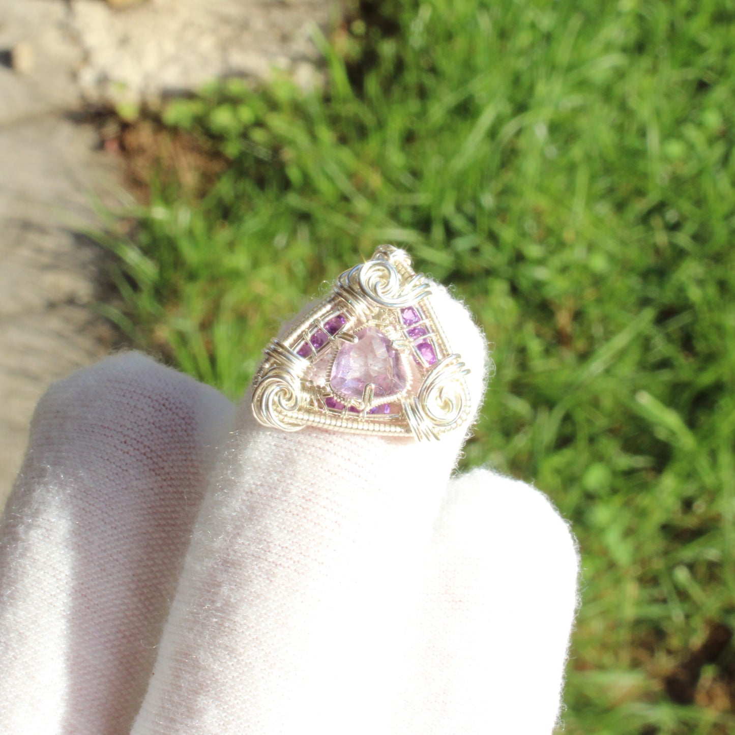 Amethyst set in sterling silver pendant with intricate wire design and purple accents