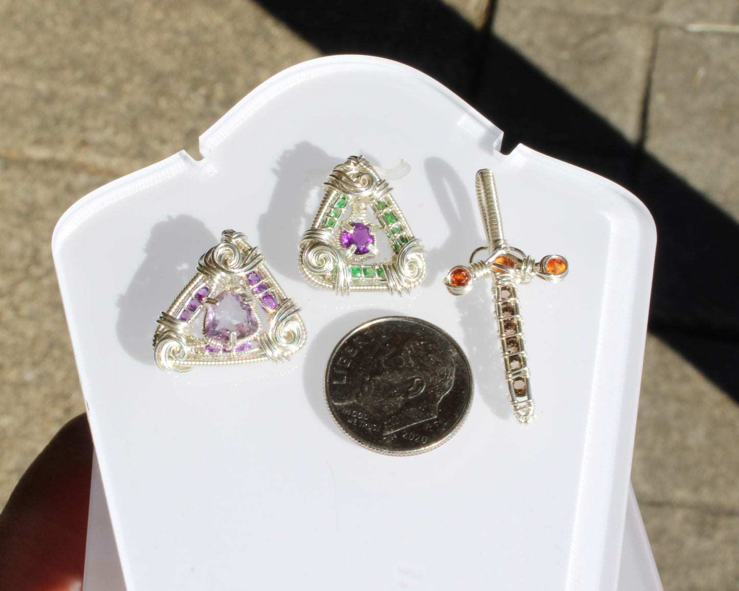 Amethyst set in sterling silver pendant alongside other decorative jewelry pieces