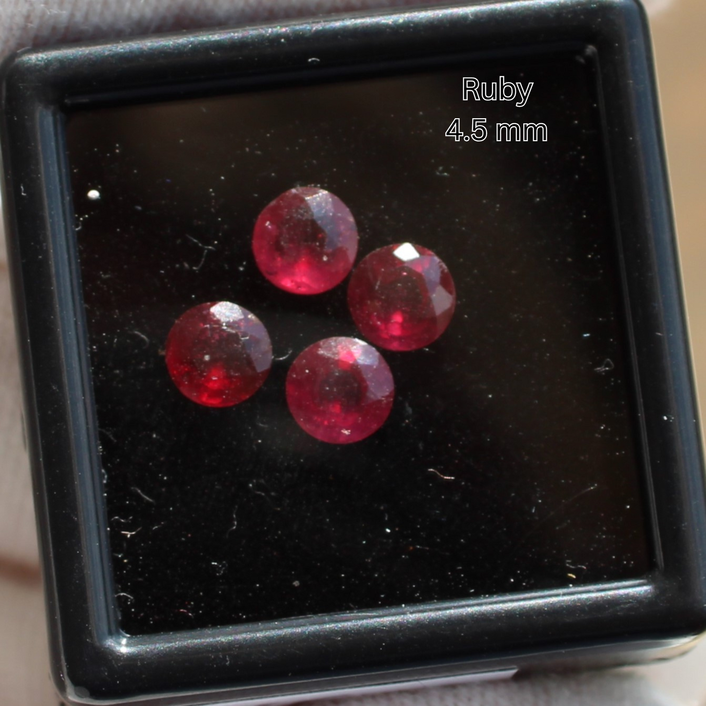 Four 4.5 mm faceted ruby crystals in a black display box for Made to order rings by Different Branches LLC