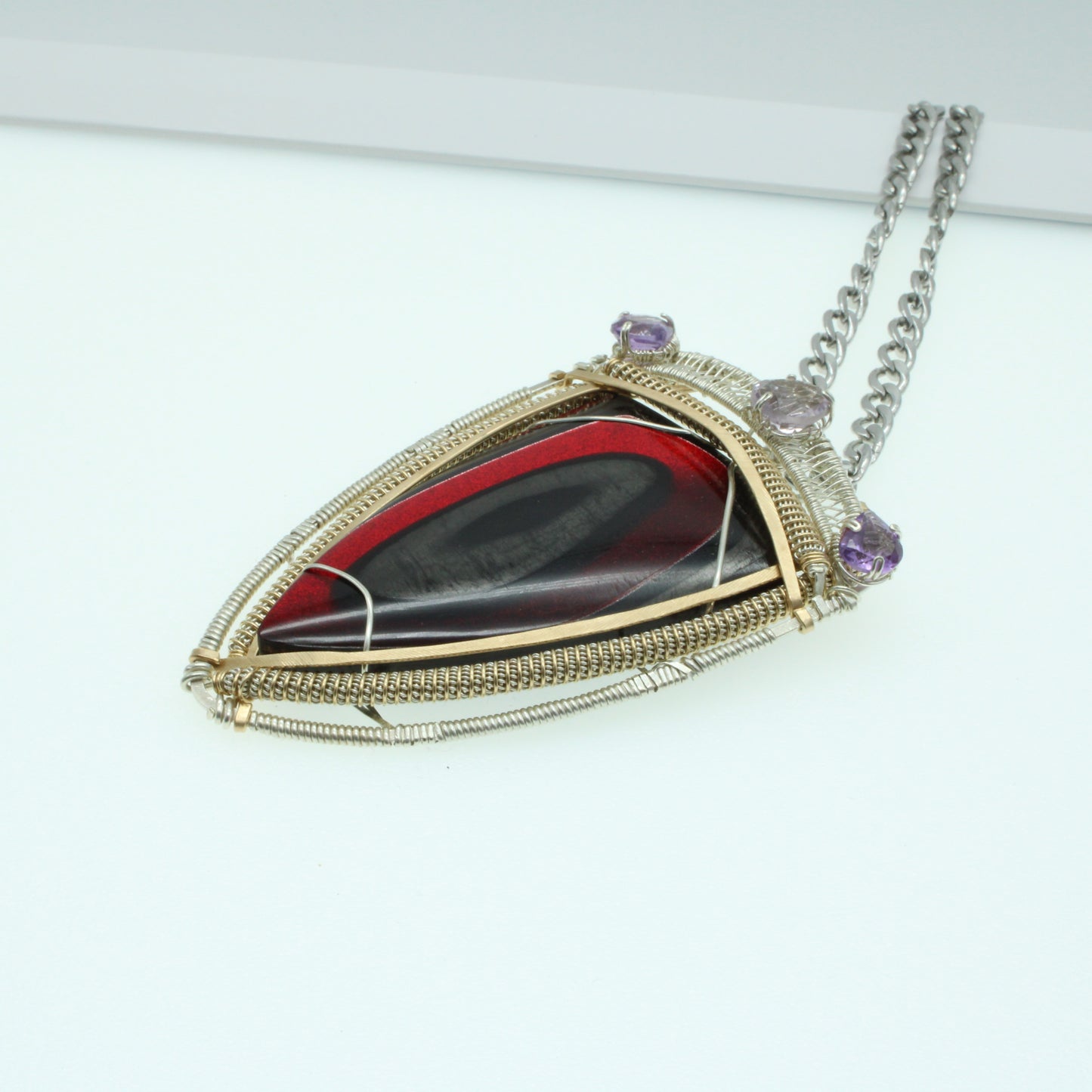 Handcrafted artisan medieval style jewelry pendant with red stone and silver wire details