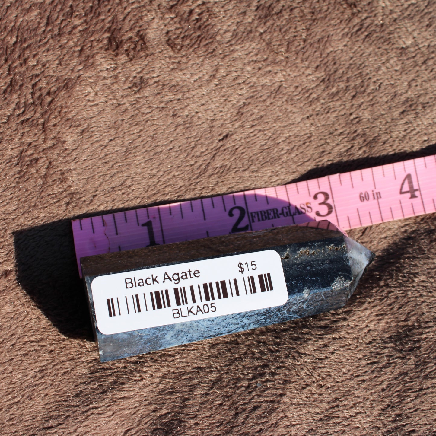 Black Agate Tower Collection displayed on a measuring tape for size reference and pricing