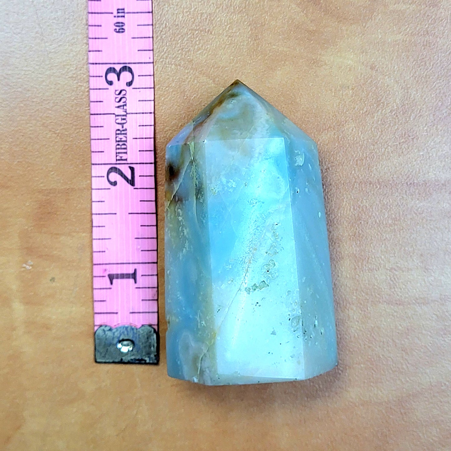 Caribbean Calcite towers in a natural shape with a smooth surface, measuring approximately two inches tall