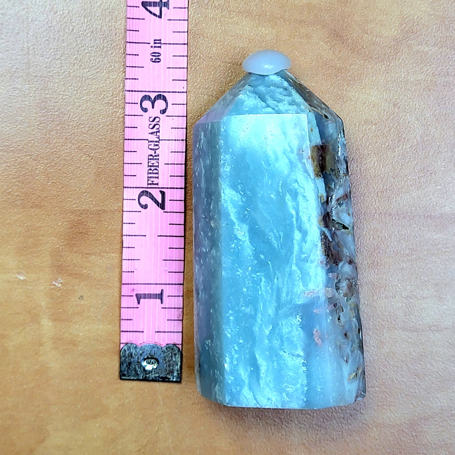 Caribbean Calcite towers in a polished finish, showcasing a unique blue-green hue next to a measuring ruler