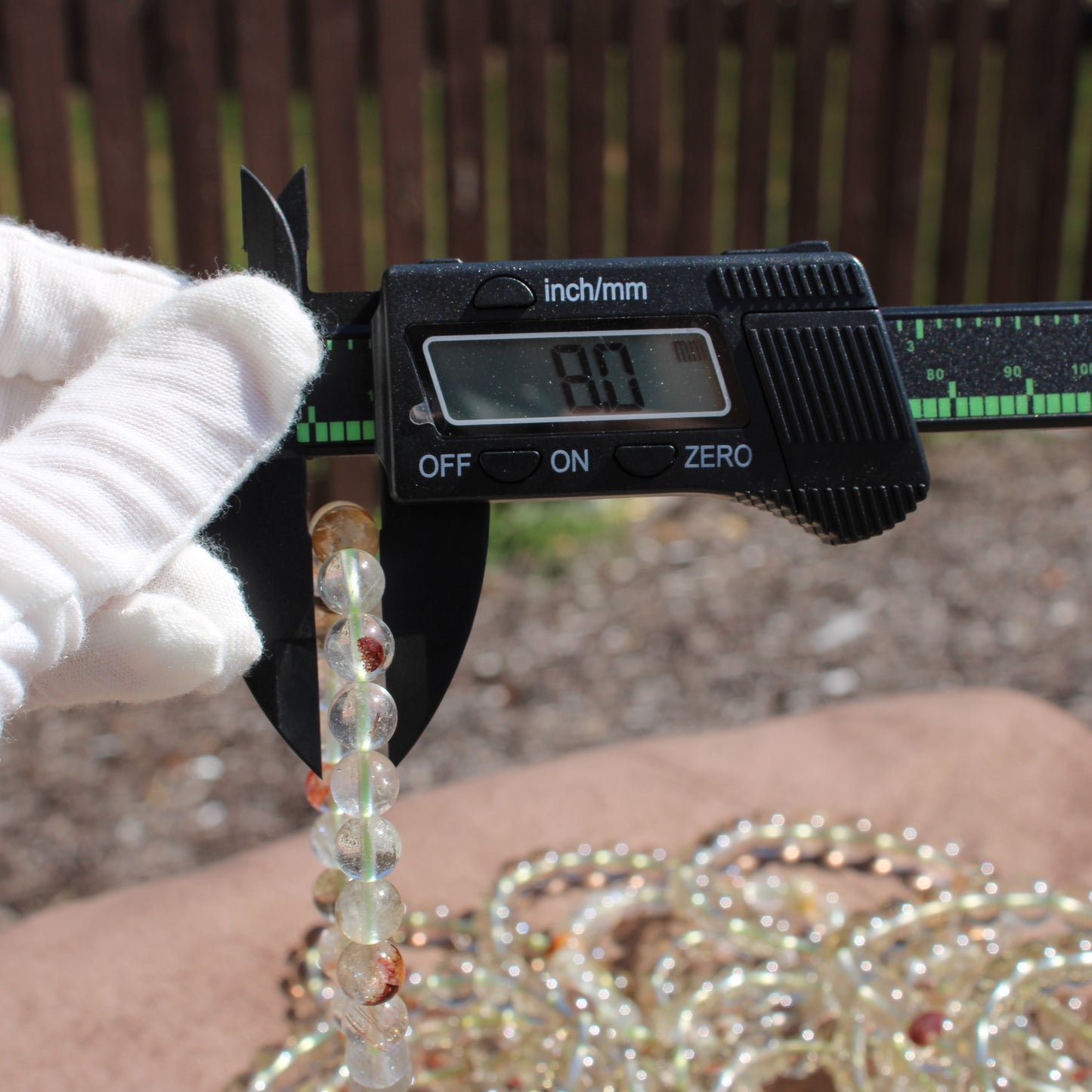 Measuring a Clear Quartz Bracelet with a caliper tool for accurate sizing details