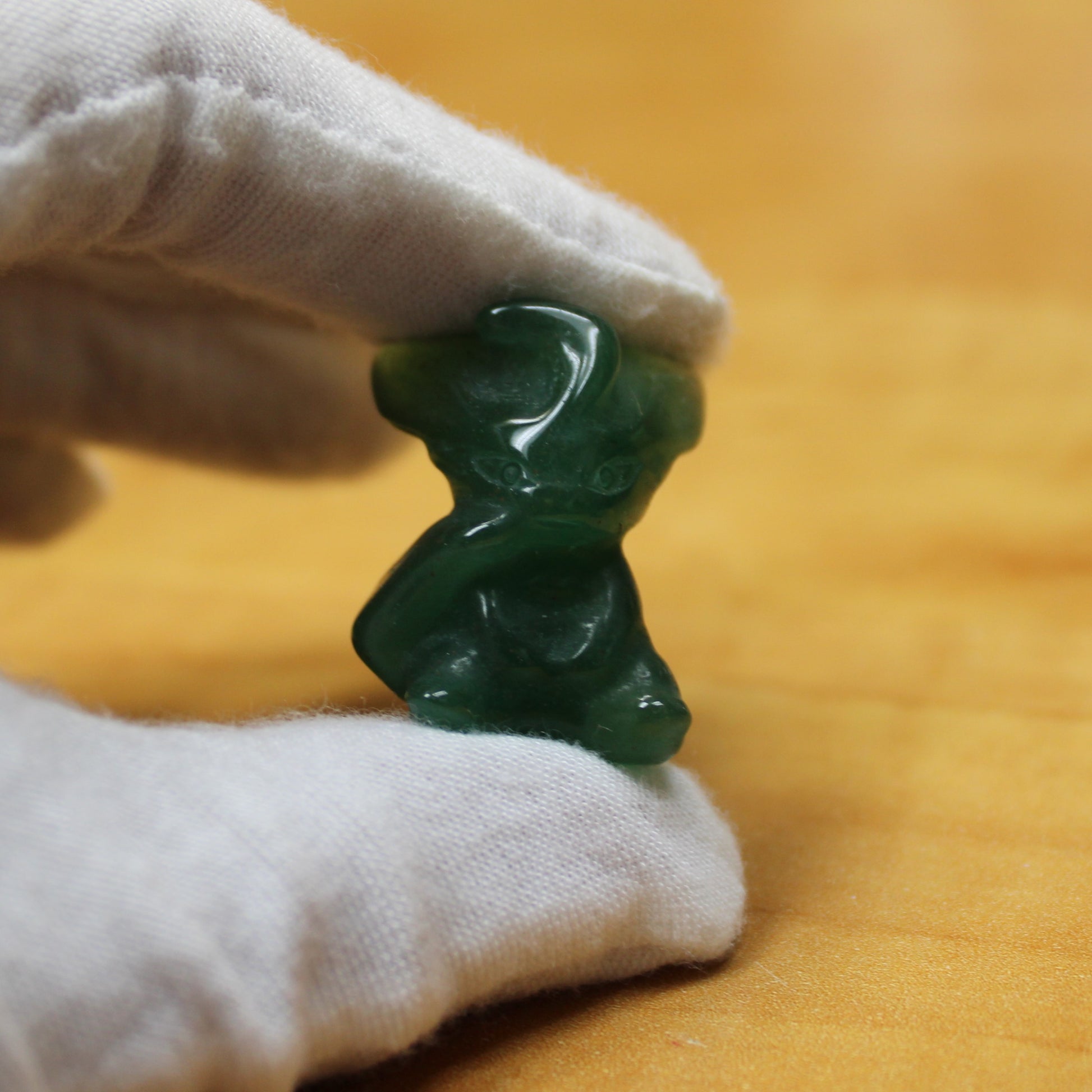 Green crystal Pokemon figurine held by white gloved hand from crystal pokemon gift set