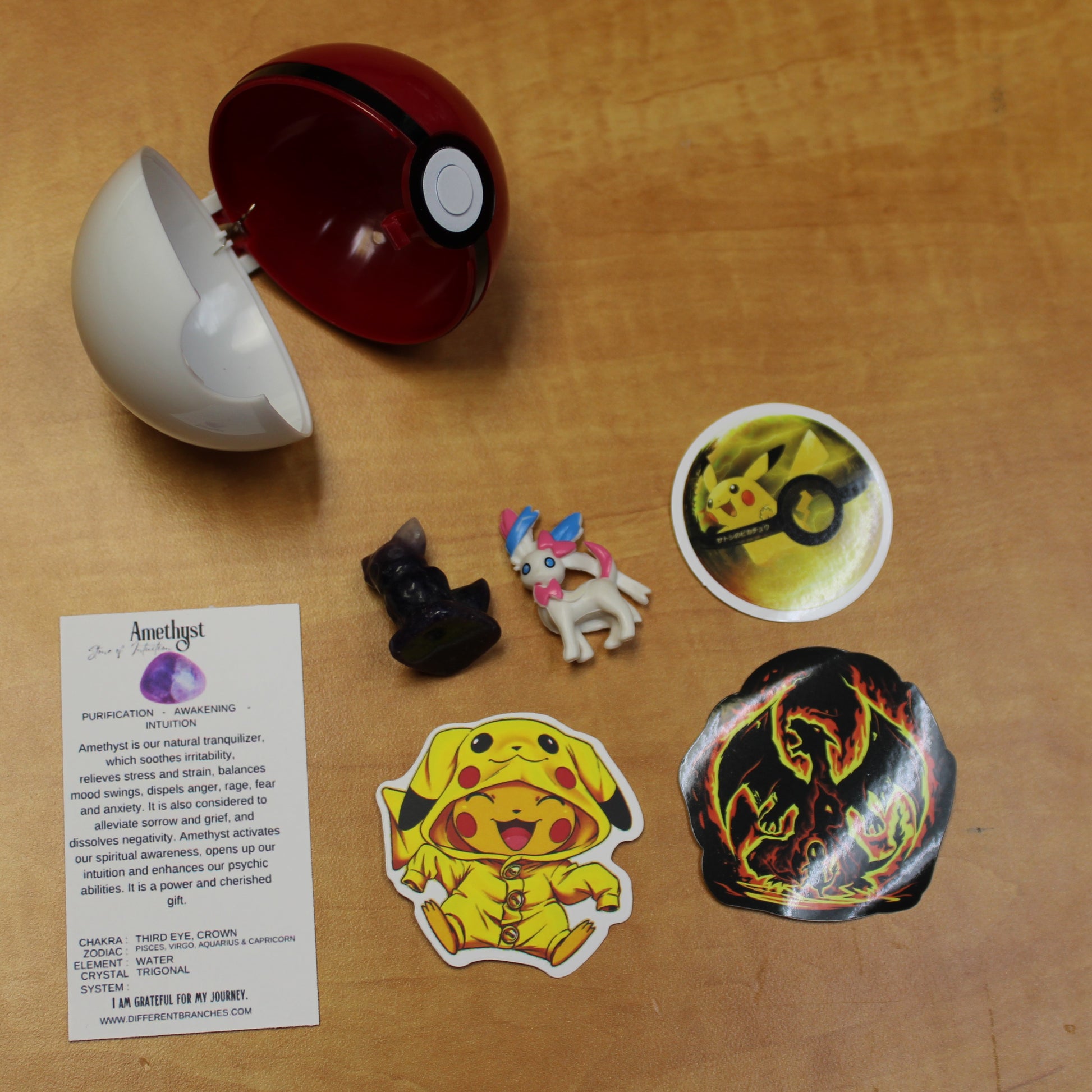 Crystal pokemon gift set featuring two small crystal figures, collectible stickers, and a red and white Pokeball container