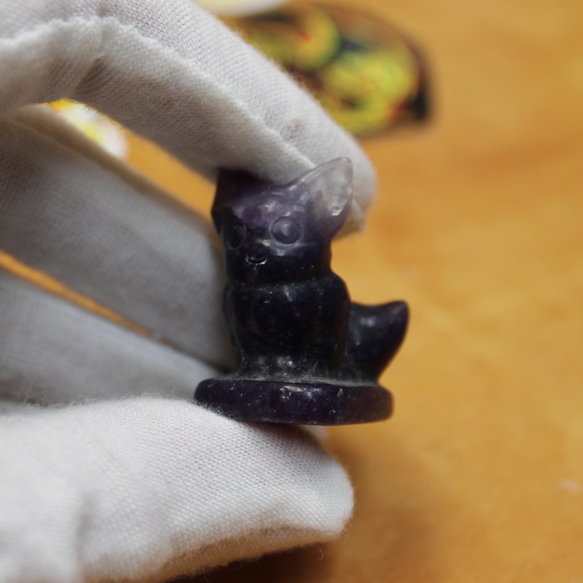 Hand holding a small dark purple crystal Pokemon gift set figurine shaped like a fox