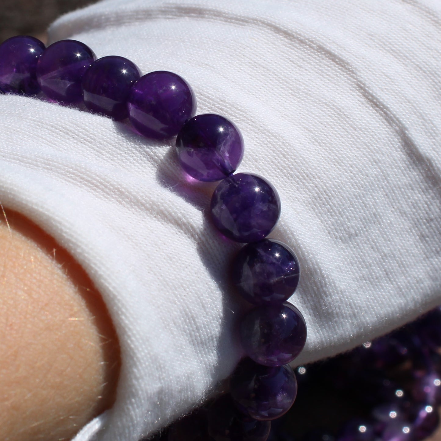Hand wearing a Deep Purple Amethyst Bracelet showcasing vibrant round beads for a stylish accessory