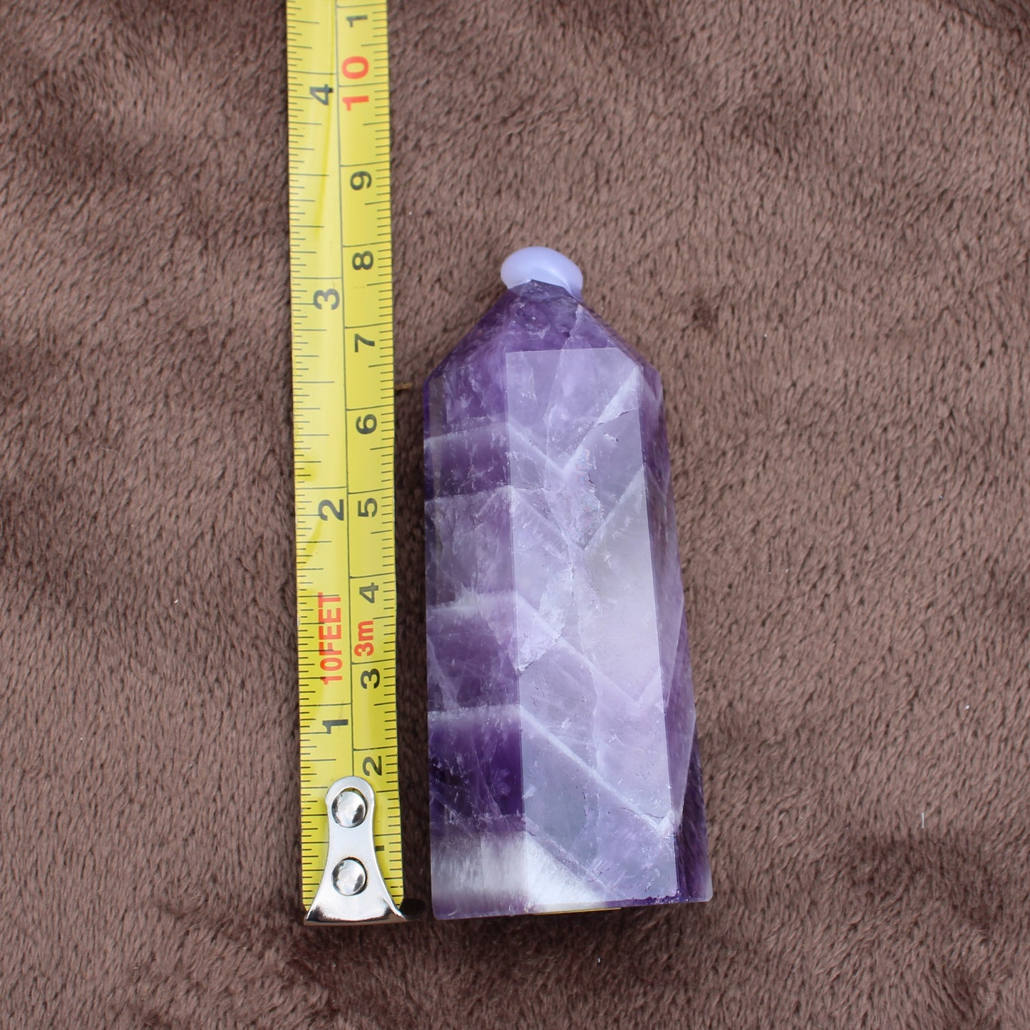 Dream Amethyst Tower crystal measuring approximately 4 inches tall on brown fabric background