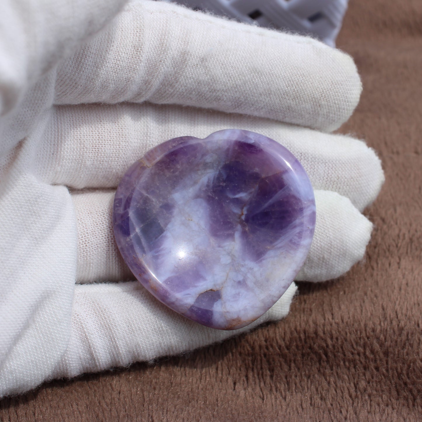 Dream Amethyst Worry Stone heart-shaped polished crystal held in white glove by Different Branches LLC
