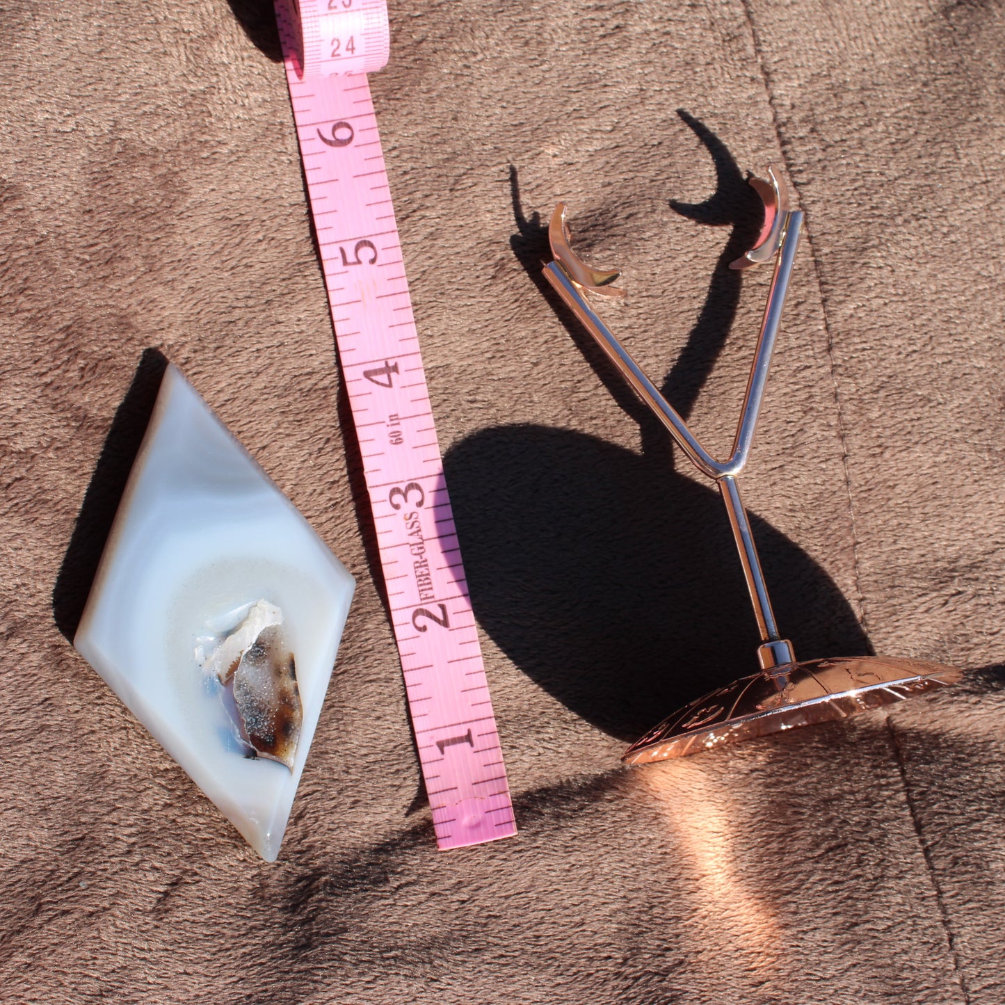 Druzy Agate Diamond with a measuring tape and display stand for showcasing the crystal sample