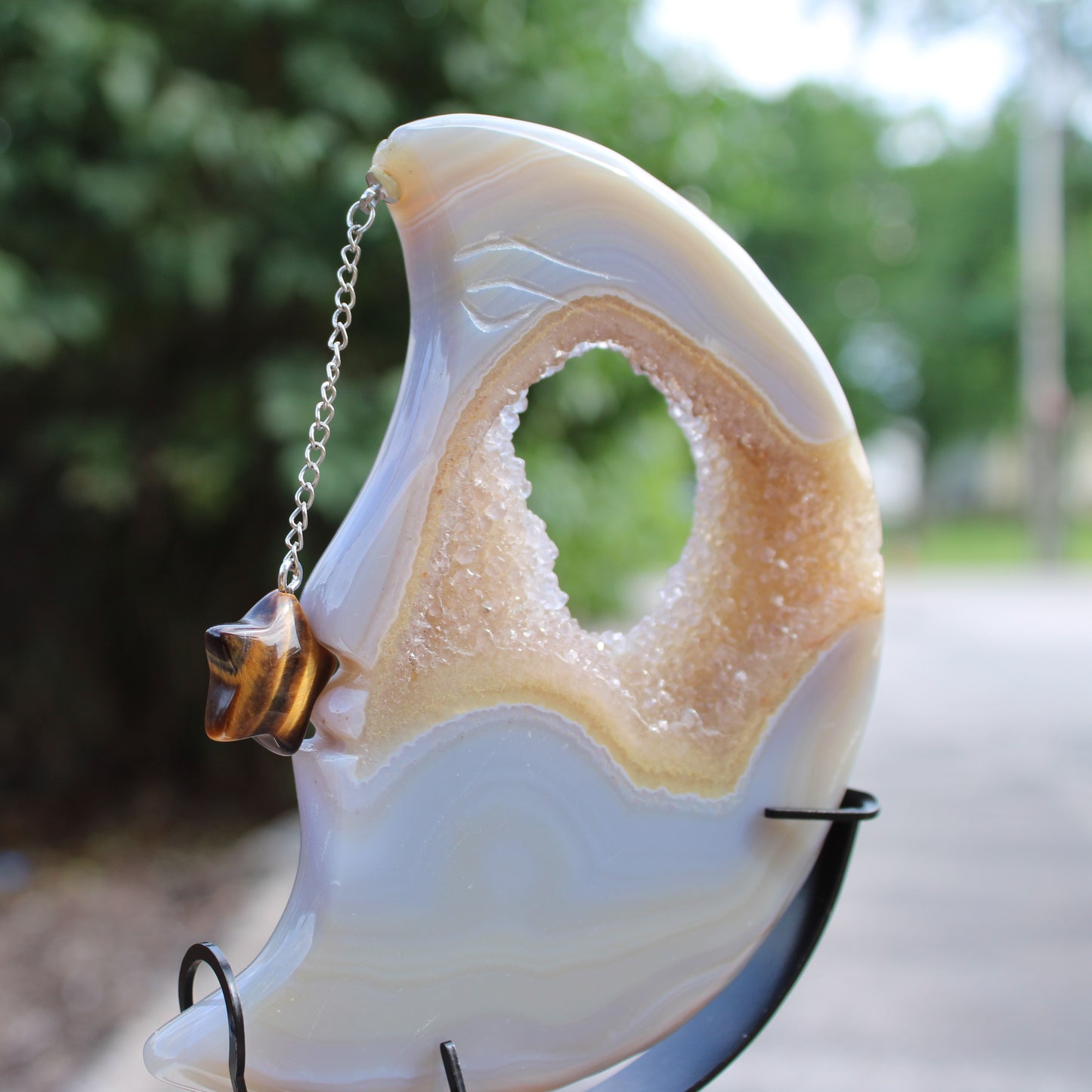 Druzy Agate Moon crystal with a carved crescent shape and hanging star charm on a display stand