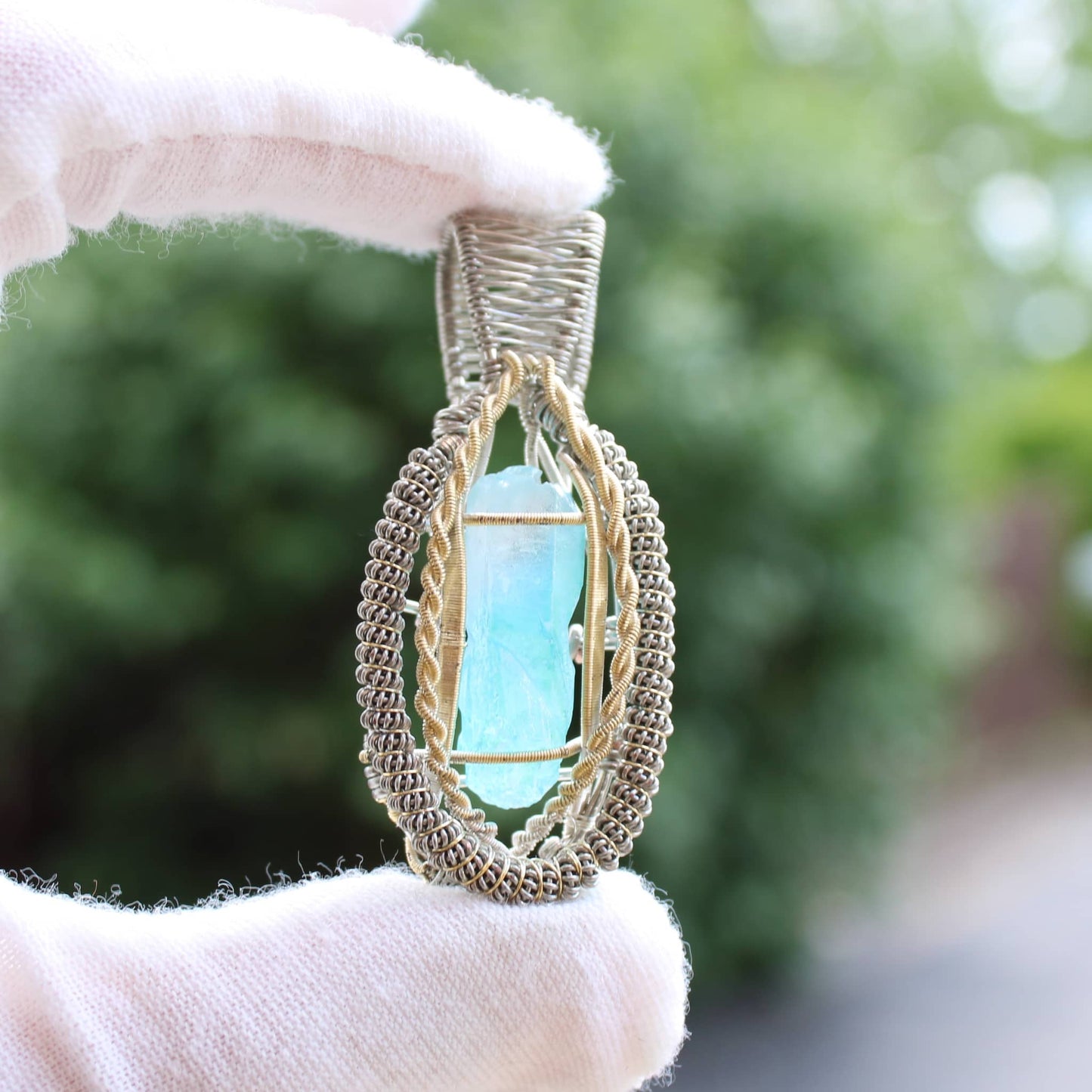Handcrafted pendant featuring electroplated blue quartz set in an intricate gold design