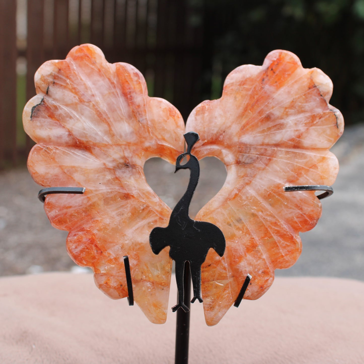 Fire Quartz Peacock Wings crystal carved in orange hues with a black peacock metal stand by Different Branches LLC