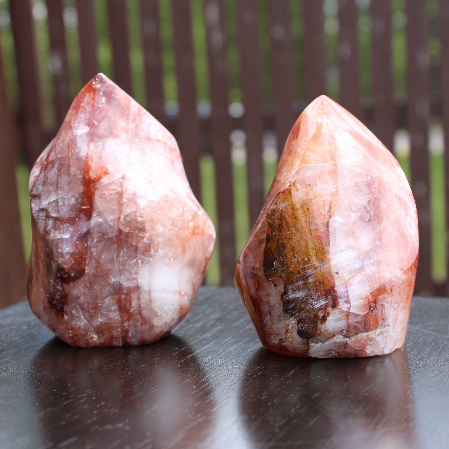 Two fire quartz torches with natural textures and colors displayed on a wooden table