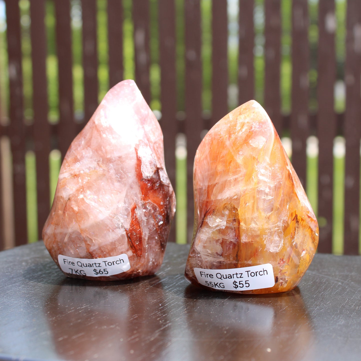 Two fire quartz torches with unique color patterns displayed on a table, ideal for home decor or crystal enthusiasts