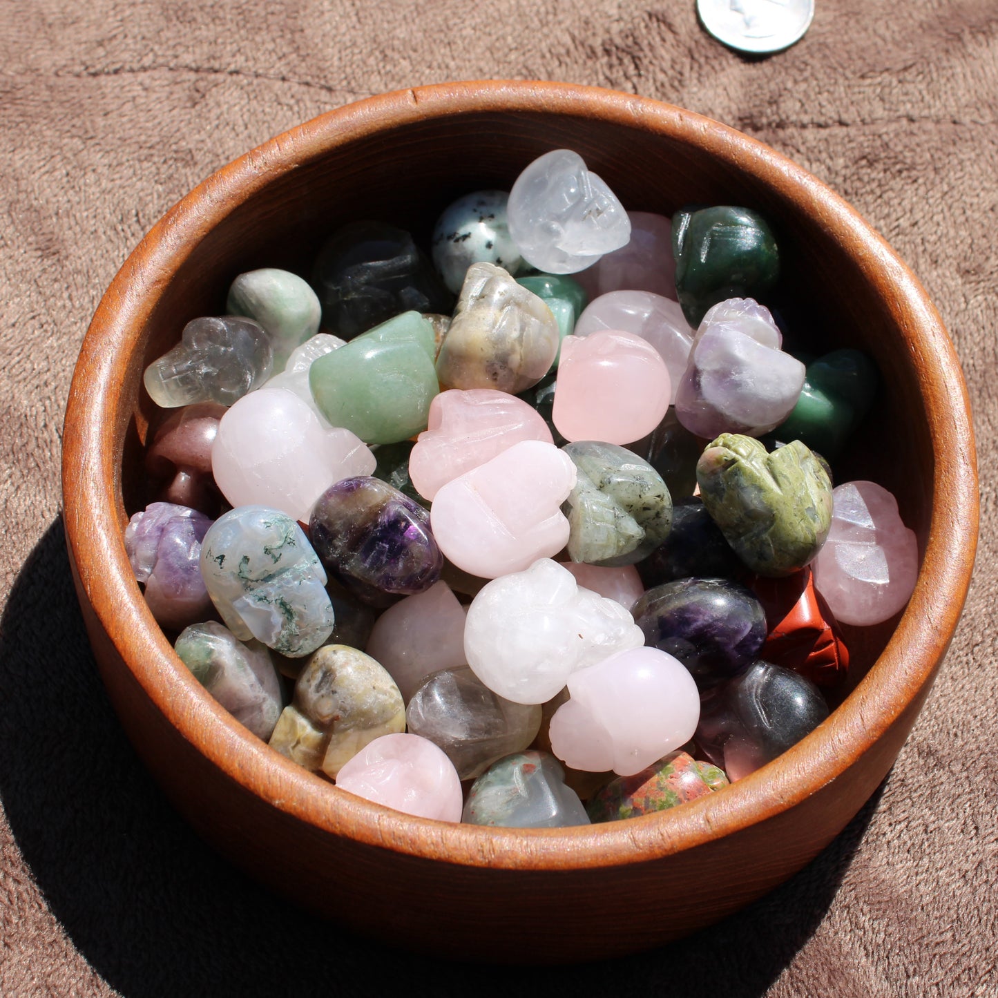 Assorted Gemstone Sugar Skull Carvings in a Round Wooden Bowl for Unique Home Decor