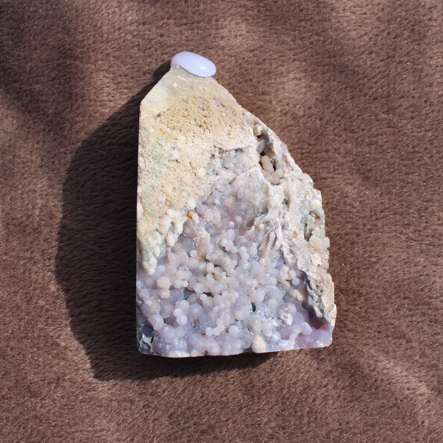 Grape Agate Tower crystal with purple botryoidal formations on a textured brown surface