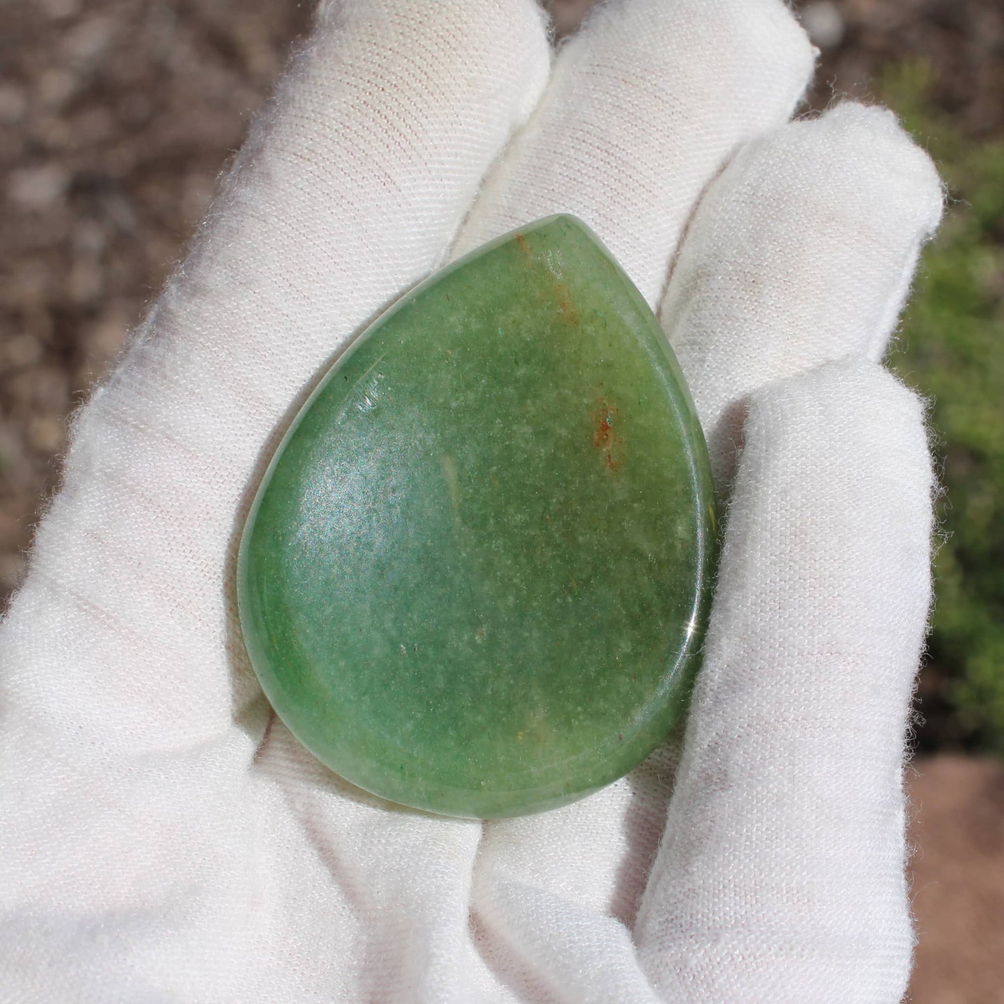 Green Aventurine Worry Stone held in a gloved hand for stress relief and meditation