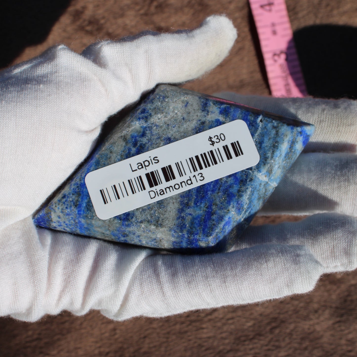 Lapis Diamond crystal displayed in hand with price tag for decorative use or collection