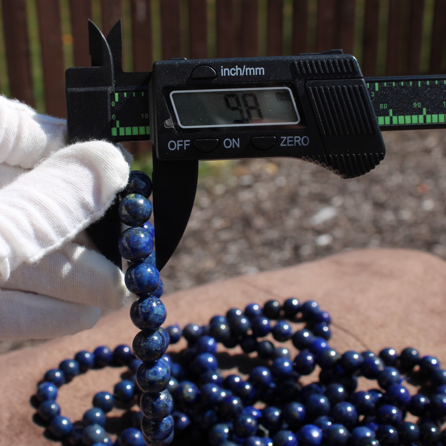 Lapis Lazuli Bracelet being measured with calipers to show size and quality of the gemstones
