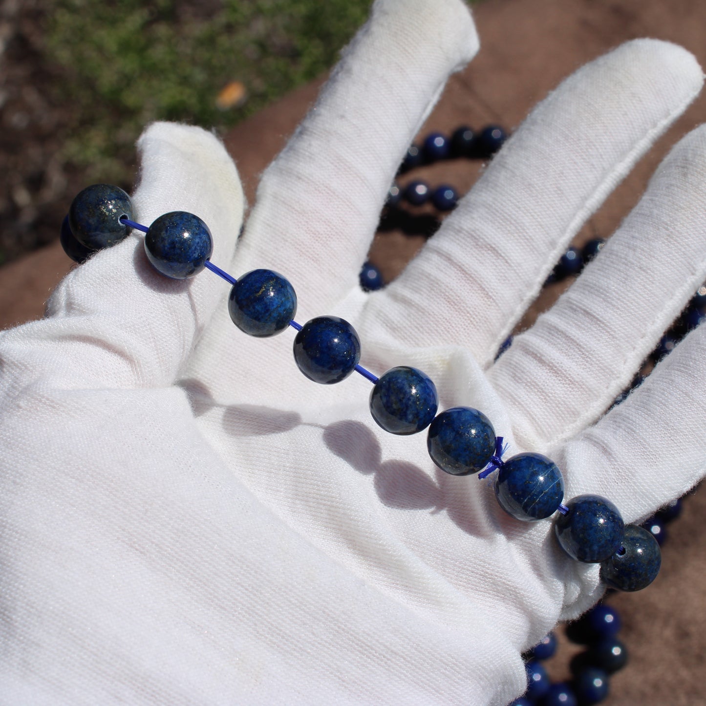 Lapis Lazuli Bracelet displayed on a gloved hand showcasing vibrant blue stones