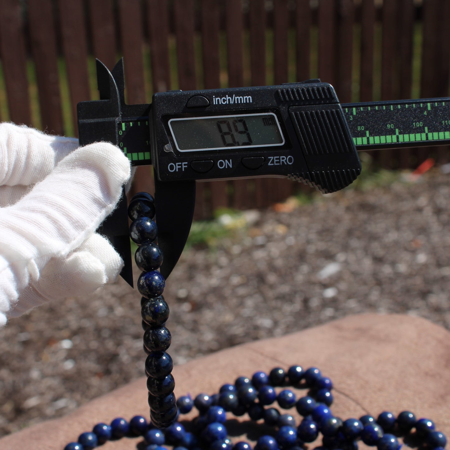 Measuring a Lapis Lazuli Bracelet with a caliper for accurate size and quality assurance