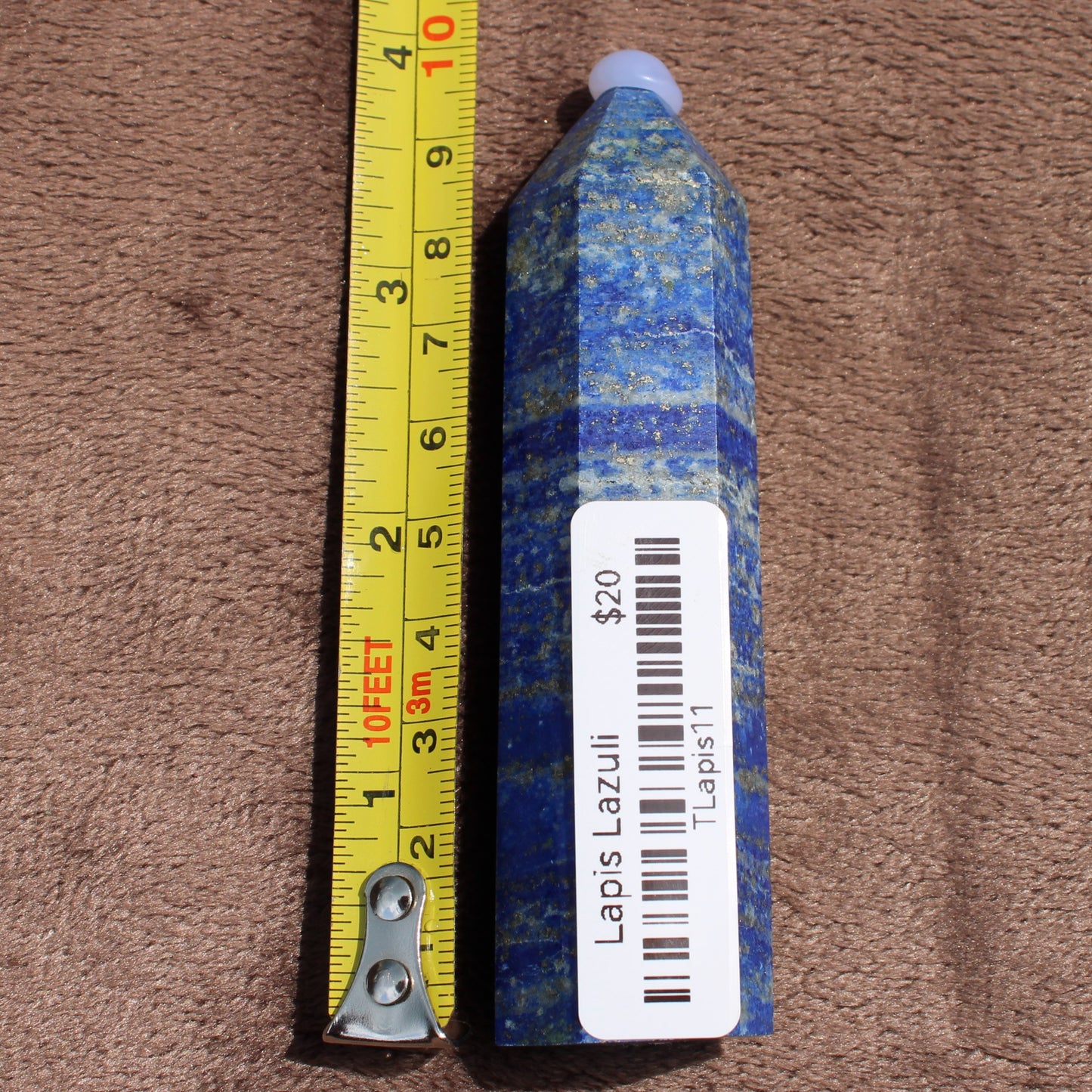 Lapiz Lazuli Tower crystal standing next to measuring tape showing size