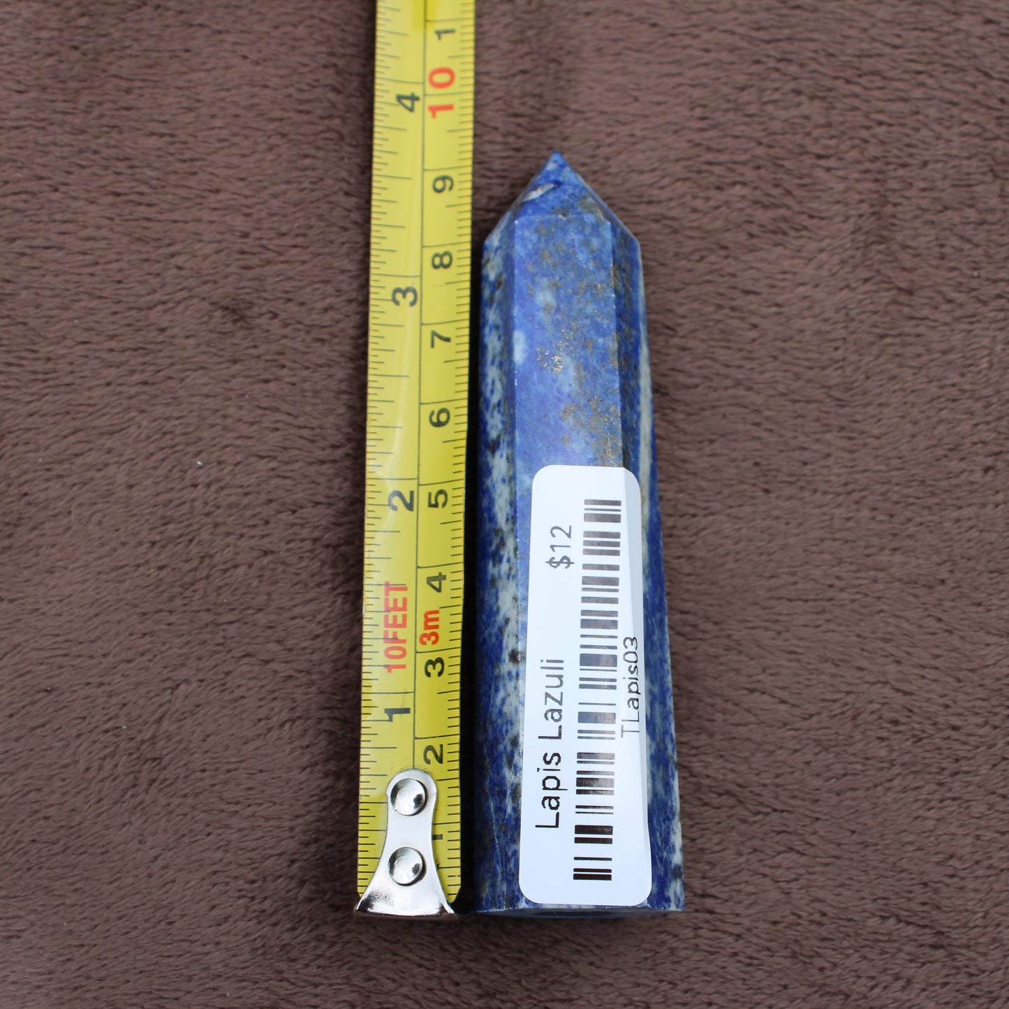 Lapiz Lazuli Tower crystal standing next to yellow measuring tape showing size by Different Branches LLC