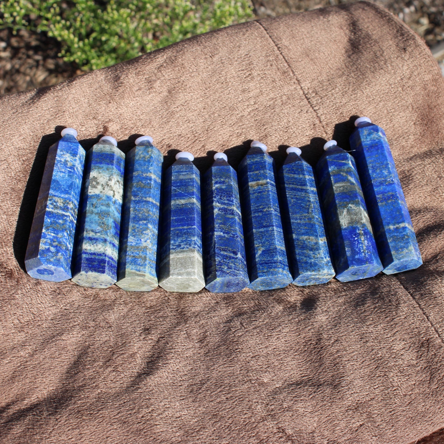 Lapis Tower Collection with multiple blue crystal towers arranged on a soft brown surface