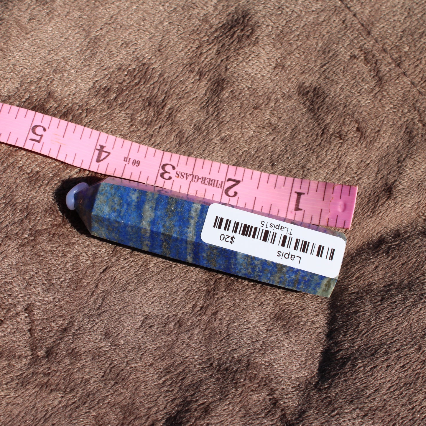 Lapis Tower Collection showcasing a polished blue lapis lazuli crystal with ruler for size reference