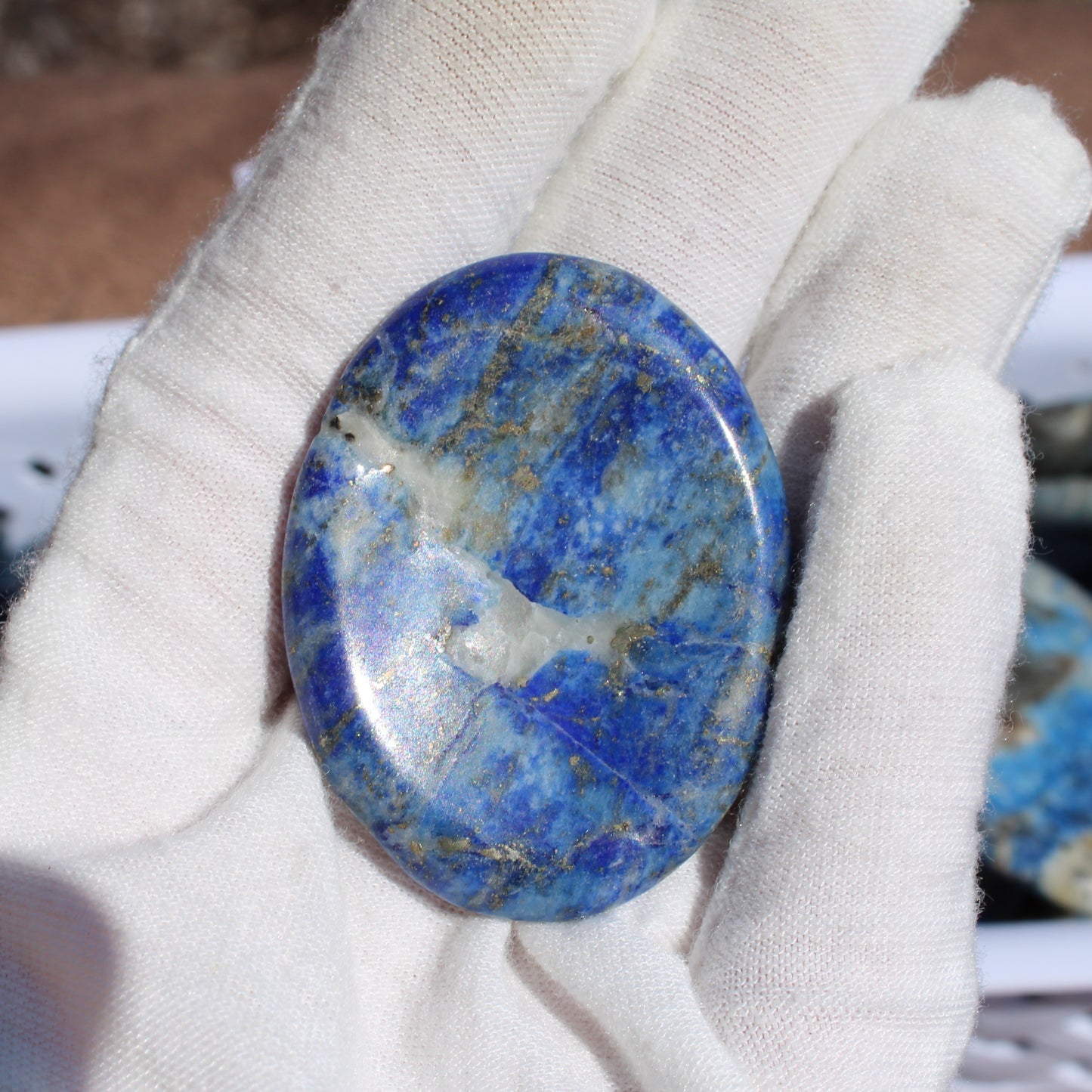 Lapis worry stone held in a hand, featuring deep blue hues and natural patterns, perfect for stress relief - Autumn 2025