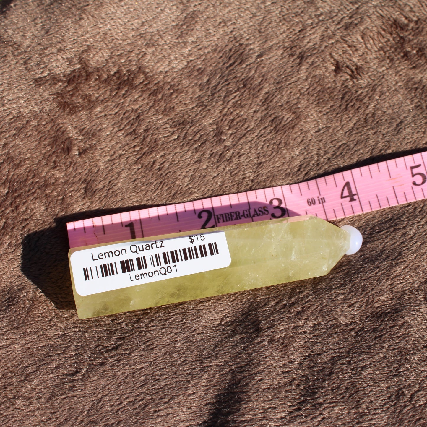 Lemon Quartz Tower with smooth edges displayed on a textured surface for crystal enthusiasts