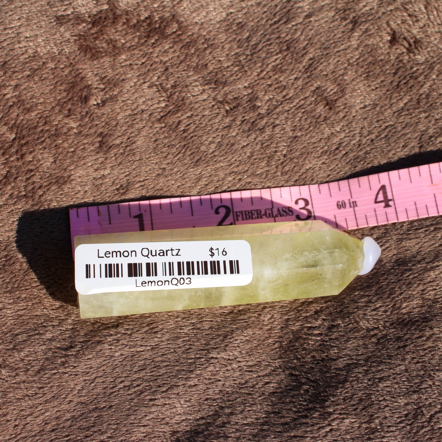 Lemon Quartz Tower from Different Branches LLC displaying a natural, yellow-green crystal shape with a price tag