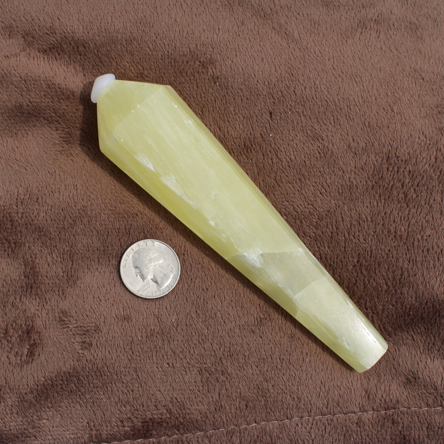 Lemon Quartz Wand crystal from Different Branches LLC next to a quarter on brown fabric background