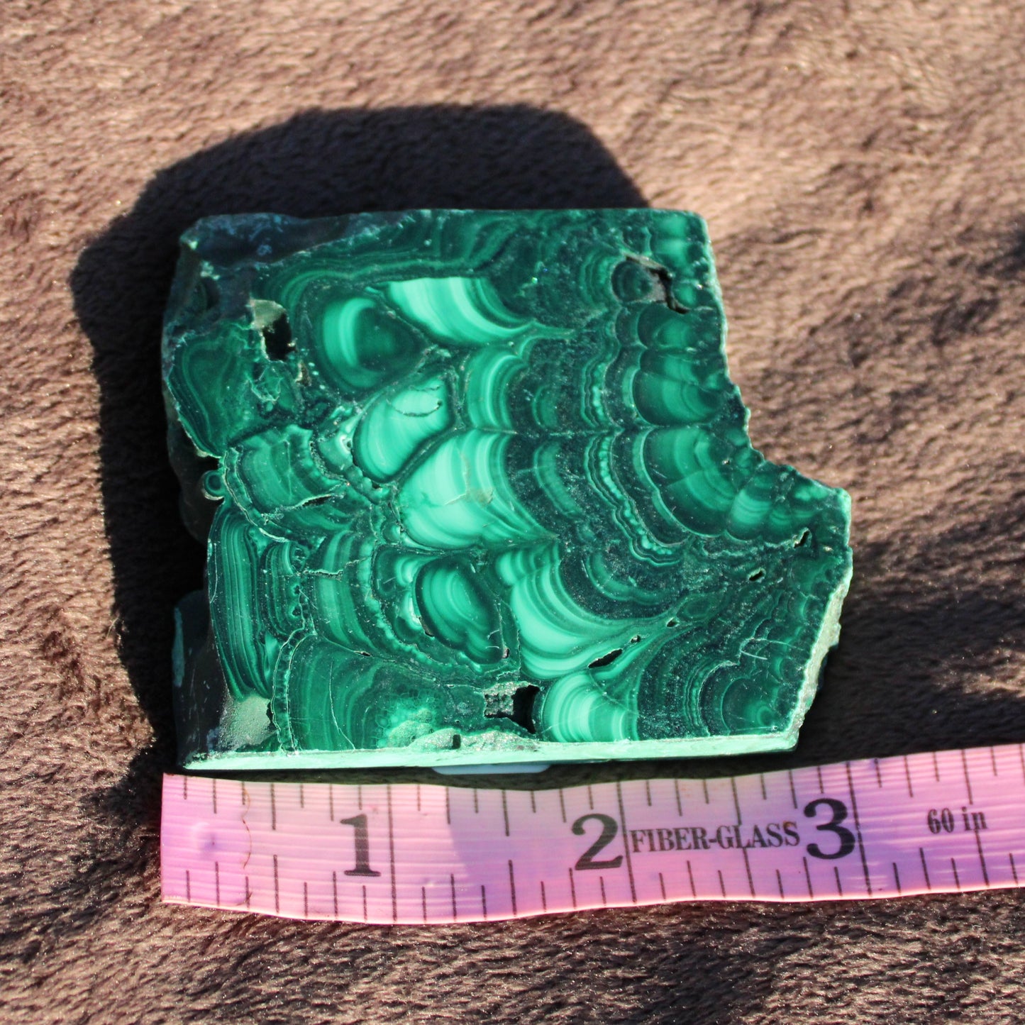 Natural Malachite slab showcasing rich green patterns, perfect for home decor or as a display piece