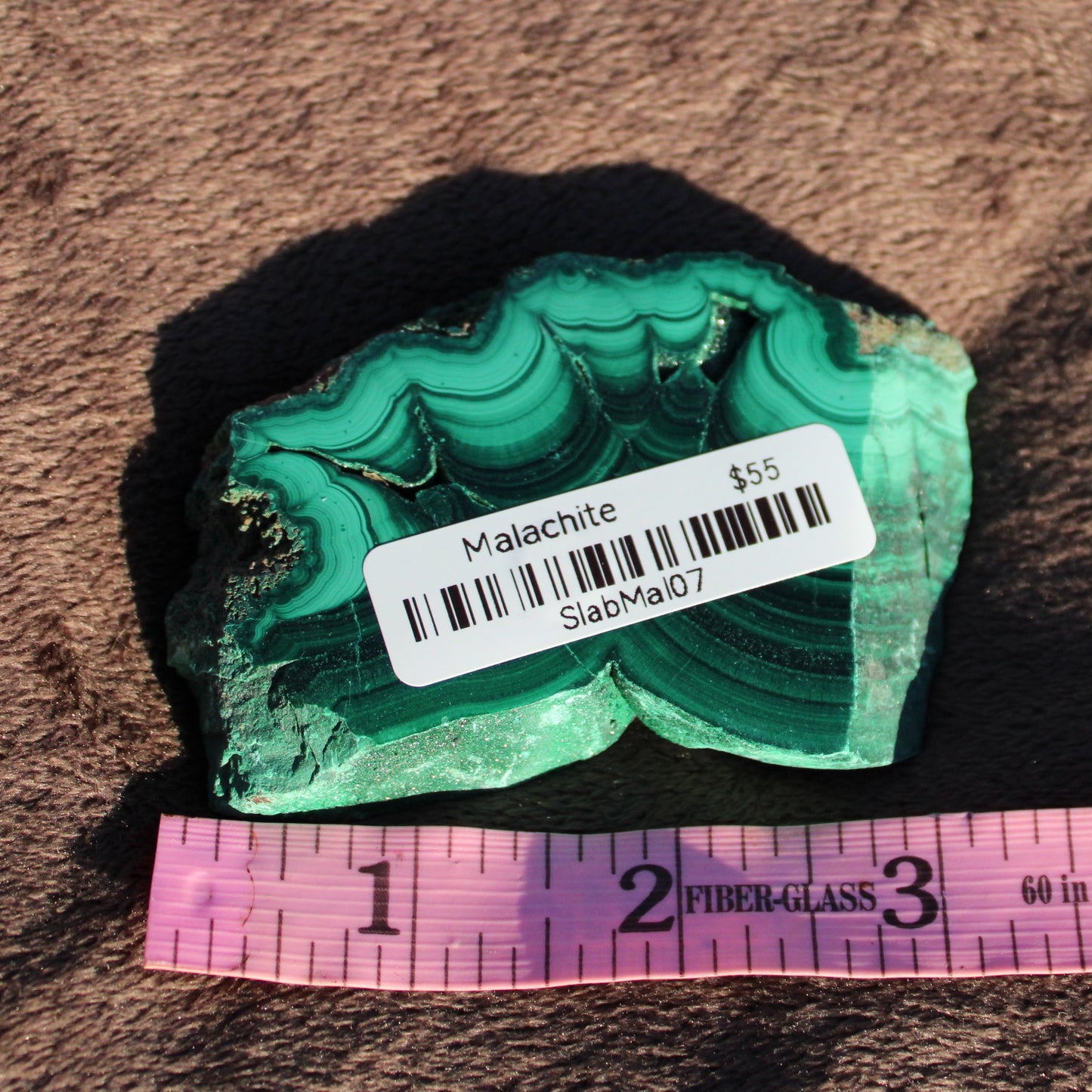 Malachite slab featuring vibrant green hues and unique banding, ideal for collectors or decorative use