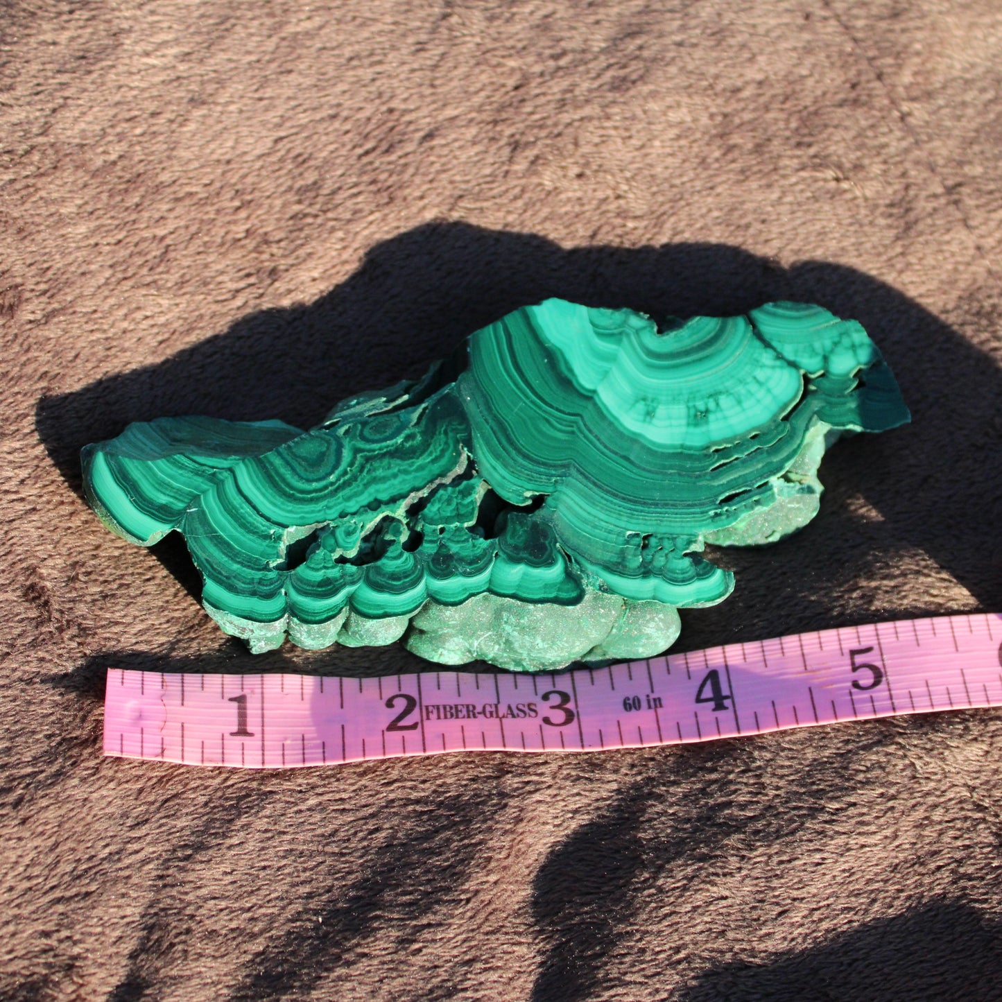 Natural Malachite slab with vibrant green layers and unique textures for home decor or crystal collectors