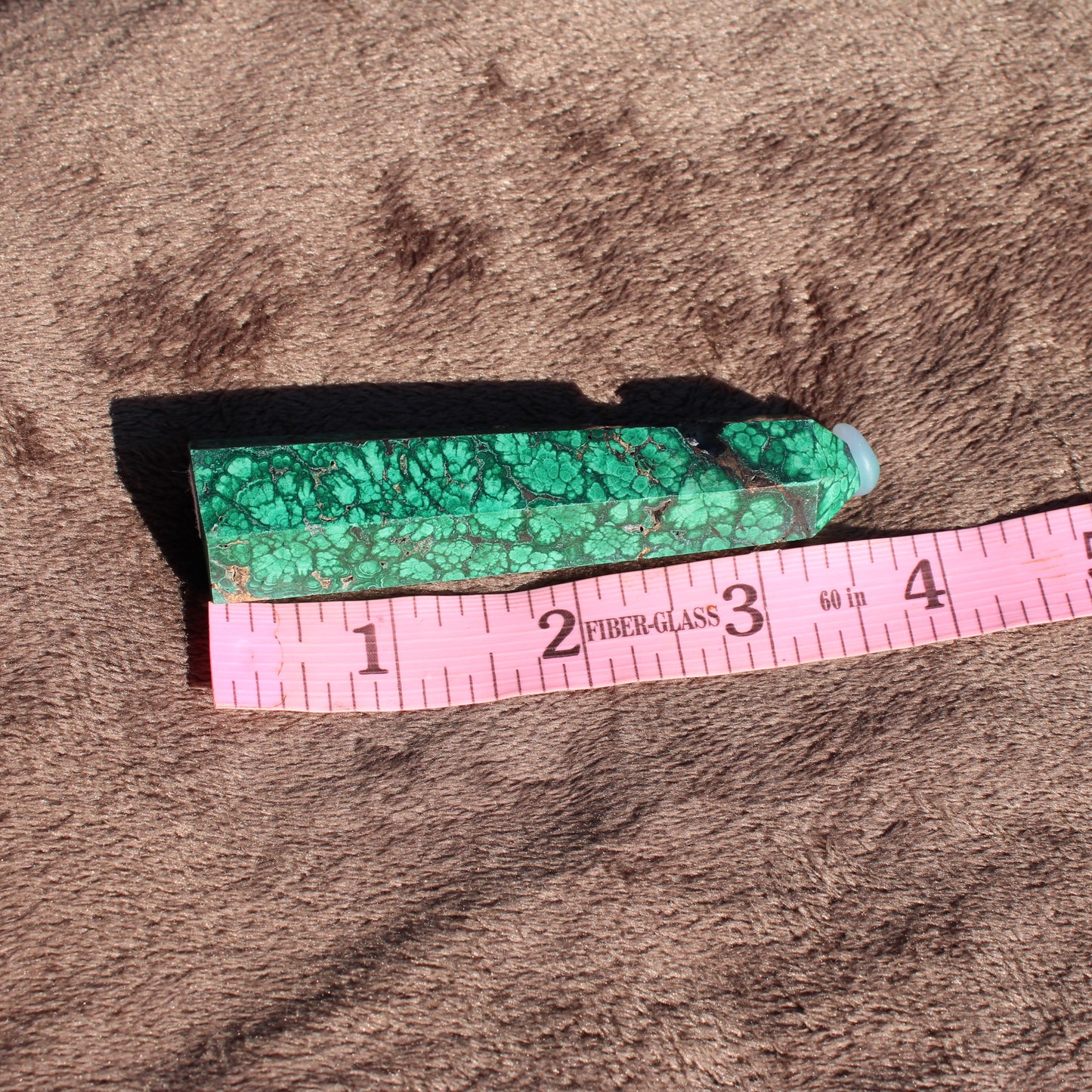 Malachite tower collection displayed with a measuring tape for size reference