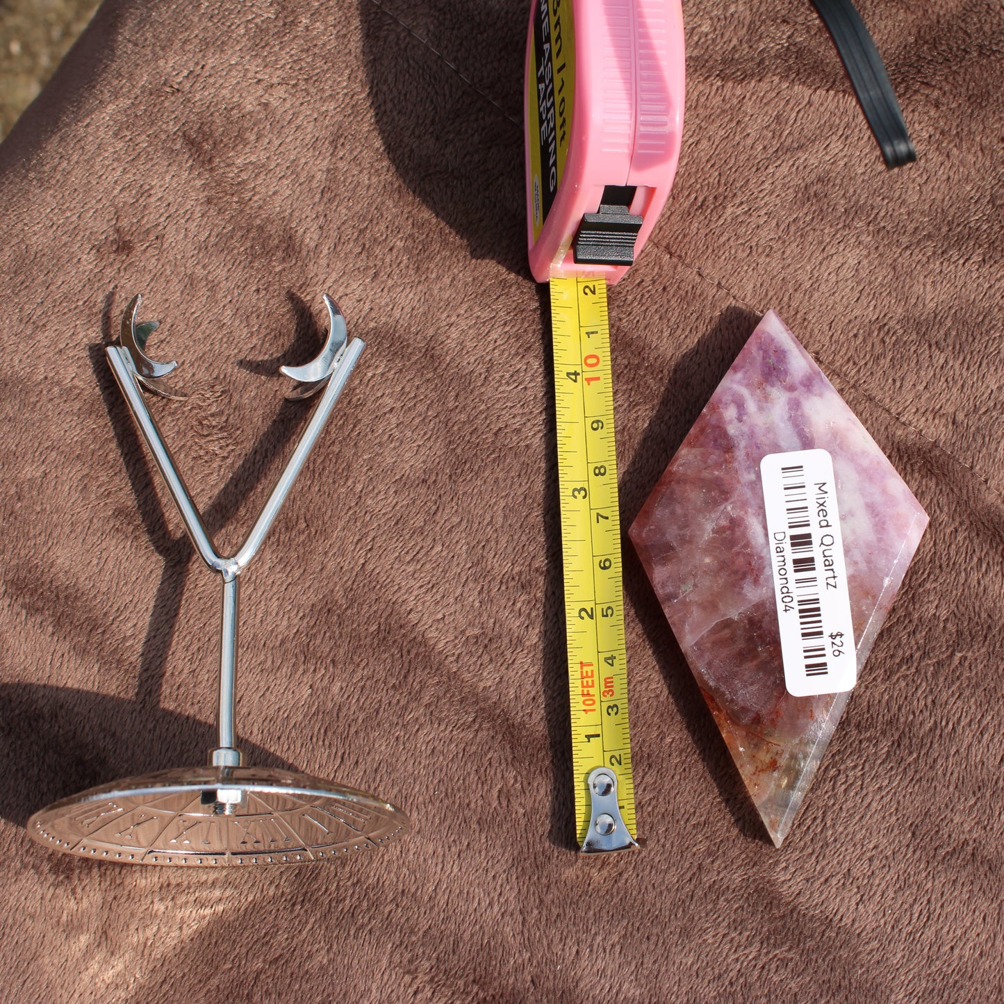 Mixed Quartz Diamond crystal from Different Branches LLC next to a measuring tape and metal stand on brown fabric