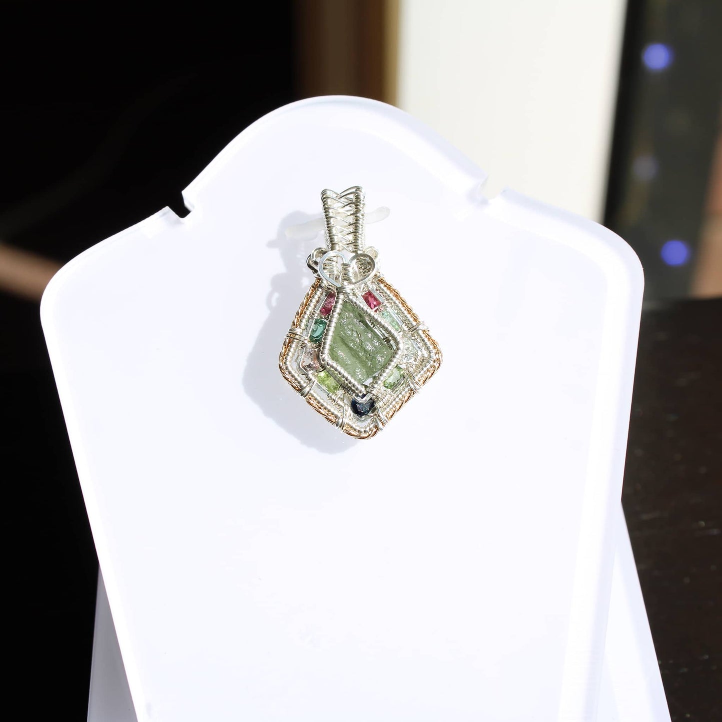 Unique Moldavite sterling silver jewelry pendant showcasing intricate craftsmanship and a vibrant green stone