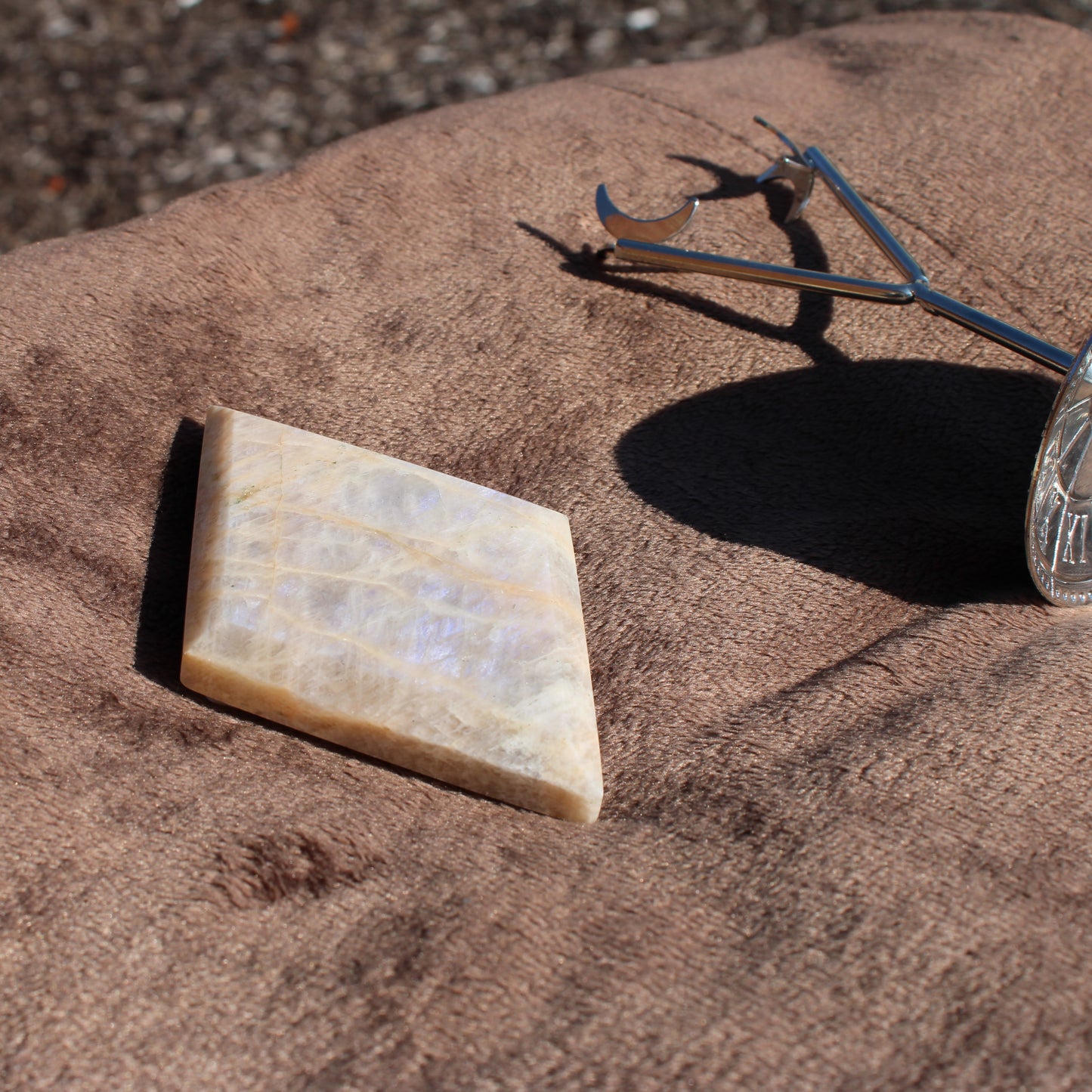 Natural Moonstone diamond slab showcasing iridescent colors on a soft fabric background