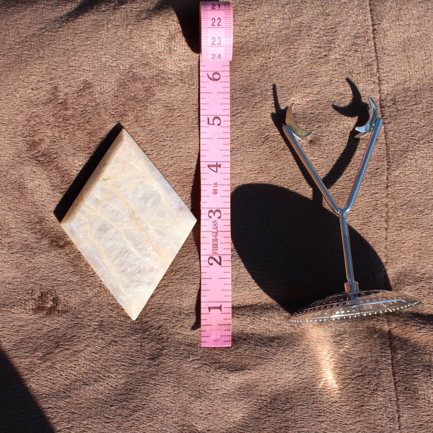 Natural Moonstone Diamond Crystal with a polished finish and a measuring tape for scale