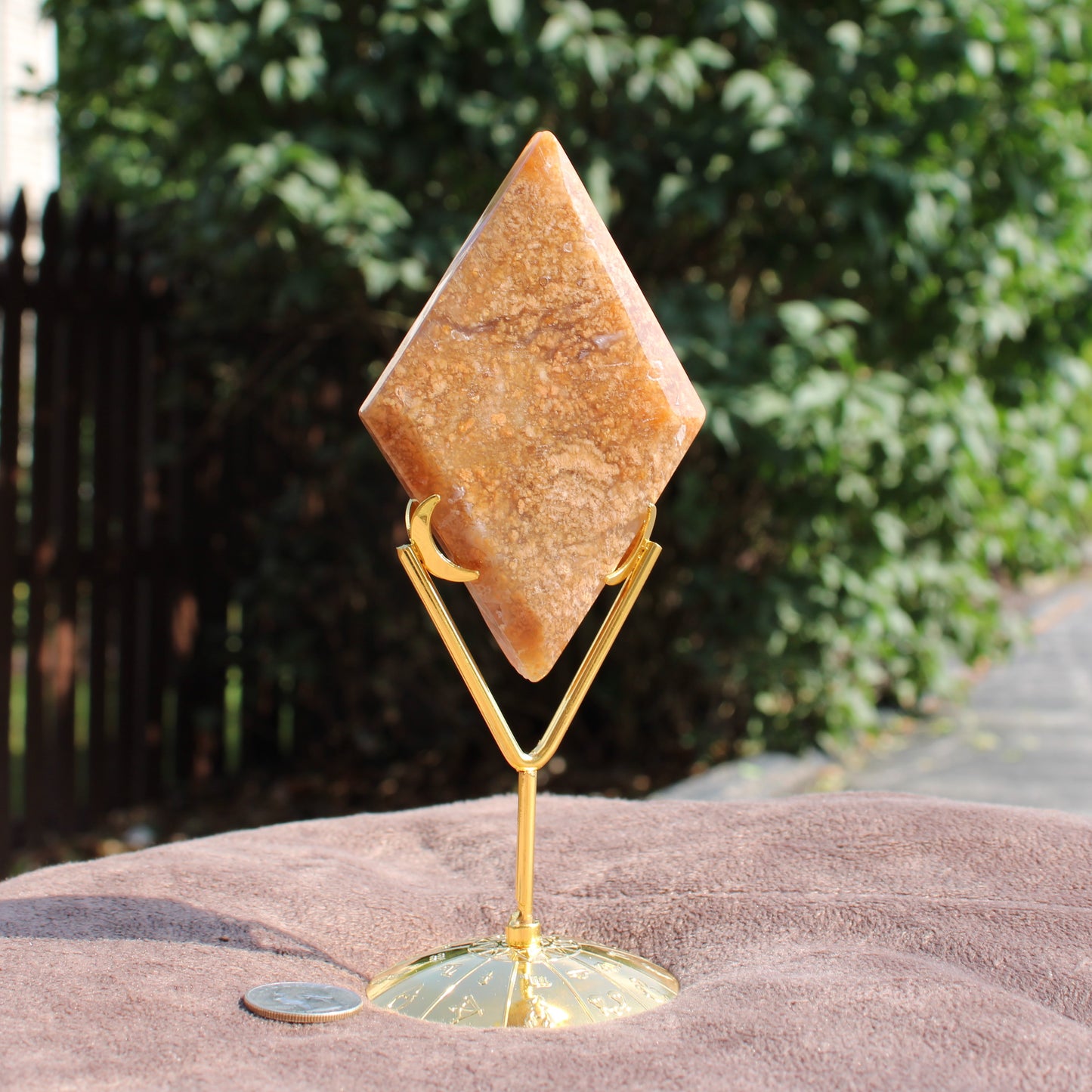 Moss Agate Diamond crystal on gold metal stand displayed outdoors by Different Branches LLC
